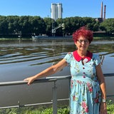 Liselotte Warnecke steht in einem blauen Kleid an einem Geländer vor der Weser und lächelt.