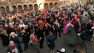 Menschen tanzen auf dem Bremer Marktplatz.