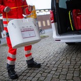 Ein Mitarbeiter des DRK stellt eine Kühlbox für eine Organspende in einen Transporter des Deutschen Roten Kreuzes.