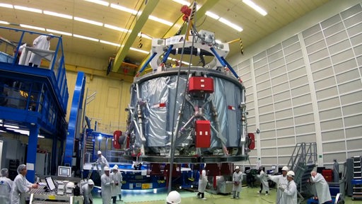 Das Orion-Raumschiff wird in einer großen Halle von Ingeneuren fertig gestellt.