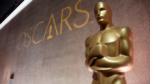 Eine goldene Oscar-Statue neben dem Schrifzug "Oscars"