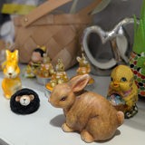 Osterhasen-Figuren stehen auf einem Regalbrett.