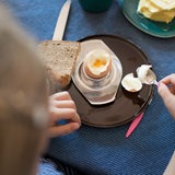 Ein Kind frühstückt ein Hühnerei.