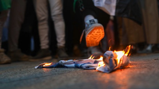 Auf einer anti-Israelischen Demo wird die Flagge Israels verbrannt und getreten (Archivbild)
