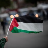 Eine Person hält eine Palästina-Flagge in der Hand