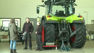 Frederik Radeke interviewt neben einem Traktor.