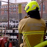 Ein Feuerwehrmann steht vor dem Pannekoekship an der Bremer Schlachte.
