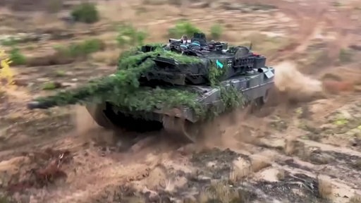 Der Leopard-Panzer fährt auf einem Acker. 