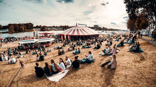 Breminale 2019, Menschengruppen sitzen am Osterdeich, Zelte sind aufgebaut