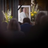 Ein Bild mit Trauerflor von Papst Franziskus steht während eines Gottesdienstes vor dem Altar 