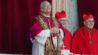 Der neue Papst steht auf einem Balkon am Petersplatz in Rom.