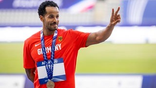 Para-Athlet Leon Schäfer mit lässigem Victory-Zeichen, nachdem er die Bronze-Medaille für den Sprint-Lauf bei der WM erhalten hat.