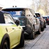 Ein SUV steht geparkt zwischen kleineren Fahrzeugen auf einem Parkstreifen am Straßenrand (Symbolbild)
