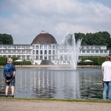 Spaziergänger laufen am Hollersee vor dem Parkhotel in Bremen vorbei.