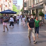 Passanten laufen in der Bremer Innenstadt in der Sögestraße zwischen den Einkaufsläden entlang.