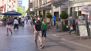 Passanten laufen in der Bremer Innenstadt in der Sögestraße zwischen den Einkaufsläden entlang.