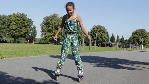 Ein Mädchen fährt mit Inline-Skates.