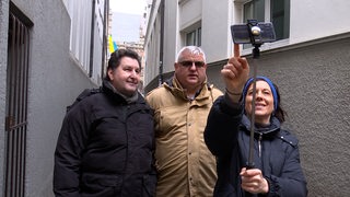 Reporterin Anna Berkhout fotografiert sich mit zwei Passanten.