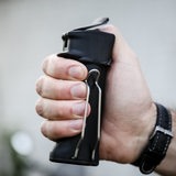 Ein Mann hält ein Pfefferspray in der Hand.