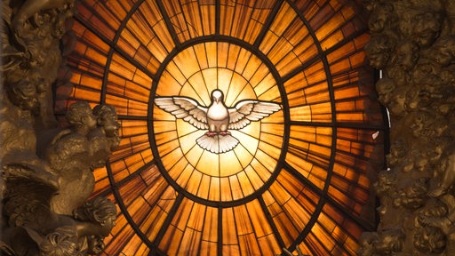 Das Fenster mit der Heilig-Geist-Darstellung leuchtet im Petersdom im Vatikan