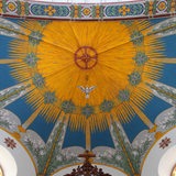 Ein Deckenbemalung in einer Kirche. Im Zentrum eine Taube.