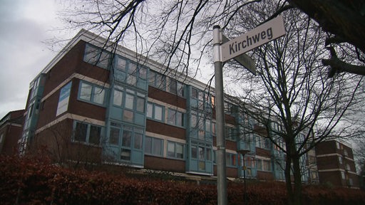Das Gebäude eines Pflegeheims mit einem Straßenschild, auf dem "Kirchweg" steht.