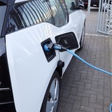 Nahaufnahme einer elektrischen Ladung bei einem Auto, die sich mit Energie auflädt