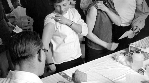 Schwarzweiß-Foto von einer Massen-Pockenimpfung im Jahr 1960