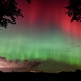 Am Nachthimmel ist ein großflächiges Polarlicht zu sehen.