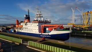 Ein Schiff fährt in den Hafen.