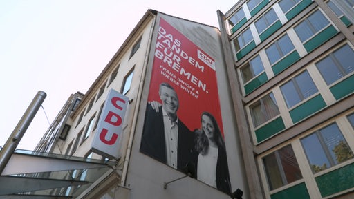 Es ist ein großes CDU Plakat an einer Hauswand zu sehen.