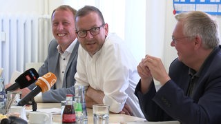 Hauke Hilz, Torsten Neuhoff und Martin Günther an einem Tisch.