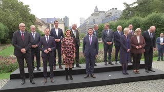 Mehrere Politiker stehen nebeneinander in einem Park auf einer Treppe. Unter anderem der Bremer Bürgermeister Andreas Bovenschulte.