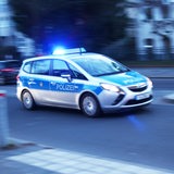 Ein Polizeiauto fährt mit Blaulicht über eine Straße