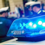 Blaulicht ist zu sehen, im Hintergrund Polizisten