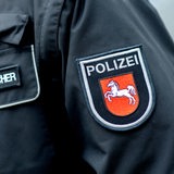 Ein Aufnäher mit dem Wappen der niedersächsischen Polizei ist auf der Jacke eines Pressesprechers der Polizei aufgebracht.