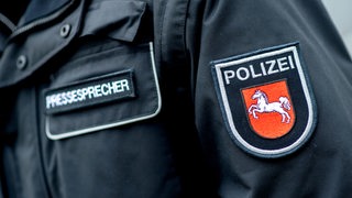 Ein Aufnäher mit dem Wappen der niedersächsischen Polizei ist auf der Jacke eines Pressesprechers der Polizei aufgebracht.