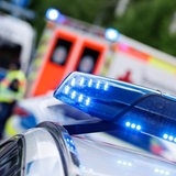 Das eingeschaltete Blaulicht ist auf einem Einsatzfahrzeug der Polizei zu sehen. Hinter dem Polizeiauto steht ein Rettungswagen.