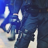 Ein Polizist hält einen Schlagstock in der Hand.