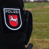 Ein Beamter der Polizei mit dem Wappen von Niedersachsen auf der Uniform.
