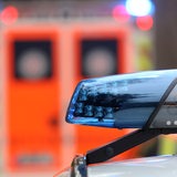 Ein Blaulicht auf einem Polizeiauto, im Hintergrund ein Rettungswagen