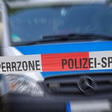 Polizeiabsperrung mit Polizeiauto im Hintergrund