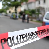 Ein rot-weißes Flatterband mit der Aufschrift "Polizeiabsperrung"