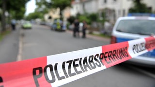 Ein rot-weißes Flatterband mit der Aufschrift "Polizeiabsperrung"