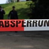 Ein rot-weißes Flatterband mit der Aufschrift "Polizeiabsperrung"