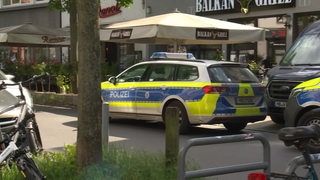 Ein Polizeiauto am Straßenrand während eines Einsatzes.
