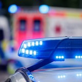 Das Blaulicht eines Polizeiwagens, im Hintergrund ein Rettungswagen