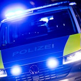 Ein Polizei-Einsatzfahrzeug steht mit eingeschaltetem Blaulicht an einer Einsatzstelle.