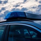 Ein Polizeiauto vor dunklen Wolken.