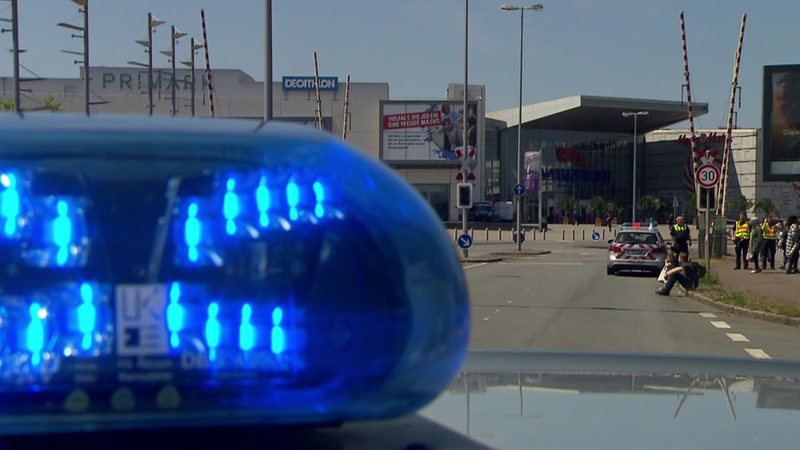 Polizeibeamte und Streifenwagen vor der Waterfront Mall Bremen.